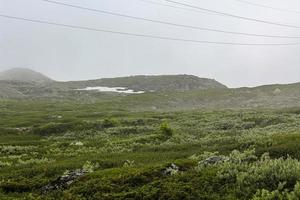 nevoeiro, nuvens, rochas e falésias na montanha de veslehodn veslehorn, noruega. foto