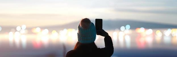 vista traseira do viajante adulto mulher moderna com manhã de nascer do sol com nevoeiro nublado e bokeh da cidade foto