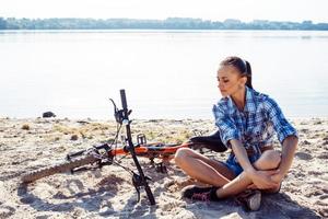 mulher de bicicleta na praia foto