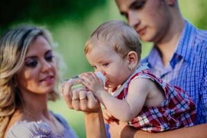 feliz mãe, pai e filha no parque foto