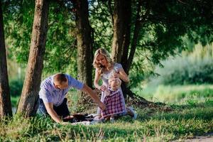 família feliz está andando no parque verde de verão foto