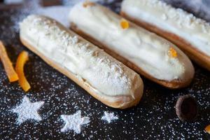 eclairs franceses tradicionais com chocolate. sobremesa saborosa. eclairs de bolo caseiro. massa de sobremesa doce recheada com creme. cobertura de chocolate. foto