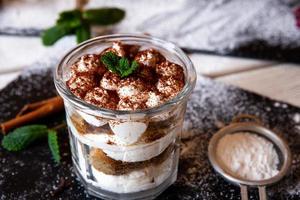 bolo tiramisu em vidro, sobremesa italiana clássica com creme de mascarpone e cacau. foco seletivo. foto