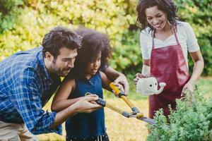 atividade de férias em família feliz durante a estadia em casa dos pais na jardinagem do quintal com crianças. foto