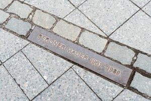 placa comemorativa marcando o antigo muro de berlim fronteiriço foto