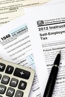 formulário de imposto e instrução com caneta e conceito de tributação da calculadora foto