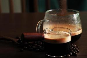 café quente forte com feijão em fundo escuro foto