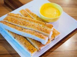 palitos de pão com molho na mesa de madeira foto