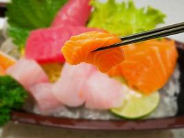 sashimi de fatia de peixe salmão fresco em pauzinhos foto