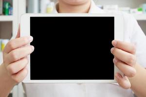 farmacêutico mostrando computador tablet na farmácia foto