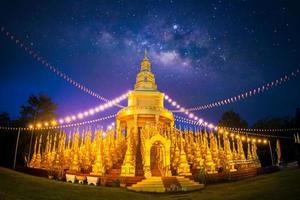 o pagode dourado com a via láctea na tailândia. foto