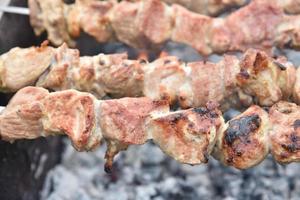 shish kebab de carne de porco em fogo sobre carvões foto