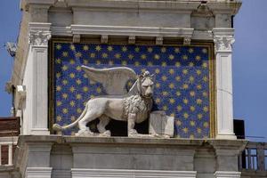 estátua de leão alado na torre do relógio na piazza di san marco em veneza, itália foto