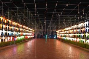 lanternas de papel lindamente moldadas e coloridas são penduradas na frente de um pagode para adorar o senhor buda em um templo no norte da tailândia. foto