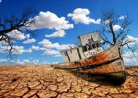 barcos em uma terra estéril. um navio em uma terra quebrada. o conceito de seca, aquecimento global e meio ambiente. foto