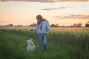 retrato de mulher e cachorrinho branco de cachorro husky nos campos foto