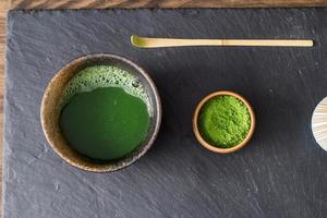 preparo de chá verde matcha em mesa de pedra preta foto