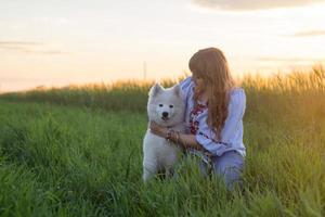 retrato de mulher e cachorrinho branco de cachorro husky nos campos foto