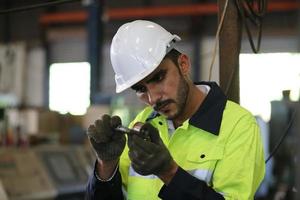 o capataz ou o trabalhador trabalham no local da fábrica verificam a máquina ou os produtos no local. engenheiro ou técnico verificando material ou máquina na planta. industriais e fabris. foto