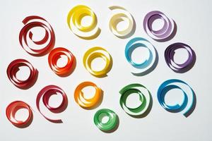 círculos de papel colorido arco-íris no fundo branco foto