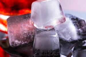 o cubo de gelo é derretido ao lado do copo de uísque