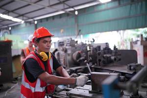 engenheiros de manutenção está trabalhando na frente do reparo automatizado de máquinas cnc em uma lista de verificação de manutenção na linha de produção. foto