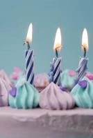 câmera lenta de vela acesa em um bolo de aniversário em fundo roxo claro