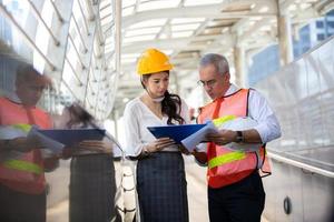 o engenheiro e a mulher de negócios verificando a área de transferência no prédio do canteiro de obras. o conceito de engenharia, construção, vida urbana e futuro. foto