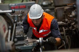 o capataz ou o trabalhador trabalham no local da fábrica verificam a máquina ou os produtos no local. engenheiro ou técnico verificando material ou máquina na planta. industriais e fabris. foto