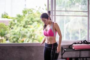 mulher jovem corpo magro relaxa após treino no ginásio de fitness.