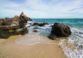 praia de areia entre rochas na ilha de koh lan tailândia foto