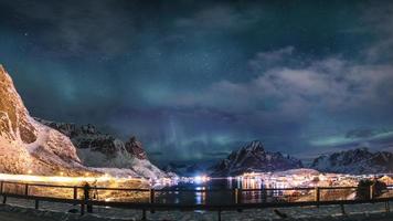 aurora boreal na vila reine com montanha nevada nas ilhas lofoten, noruega foto