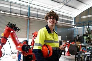 engenheiro verificando o painel de controle e ensinando novo braço robótico automático e máquina de controle operacional na fábrica. foto