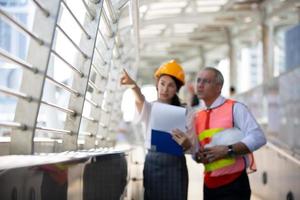 o engenheiro e a mulher de negócios verificando a área de transferência no prédio do canteiro de obras. o conceito de engenharia, construção, vida urbana e futuro. foto