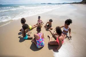 crianças brincando correndo na areia da praia foto