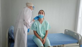proteção contra coronavírus durante a quarentena, médica fazendo exame médico para uma paciente feminina. foto