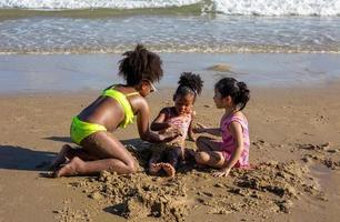 crianças brincando correndo na areia da praia foto