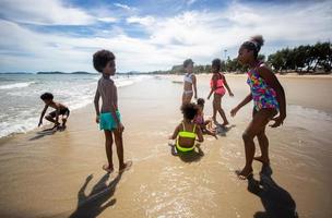 crianças brincando correndo na areia da praia foto