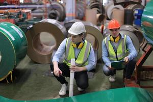 o capataz do trabalhador da indústria ou o trabalho do trabalhador no local da fábrica verificam a máquina ou os produtos no local. engenheiro ou técnico verificando material ou máquina na planta. industriais e fabris. foto