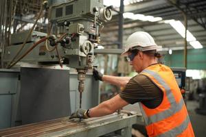 engenheiros de manutenção está trabalhando na frente do reparo automatizado de máquinas cnc em uma lista de verificação de manutenção na linha de produção. foto