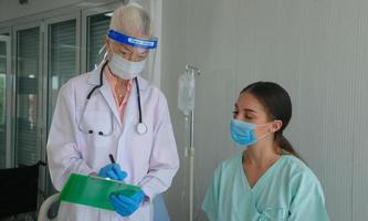 proteção contra coronavírus durante a quarentena, médica fazendo exame médico para uma paciente feminina. foto