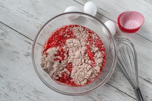 massa de bolo de veludo vermelho com ingredientes e forma plana de cupcake foto