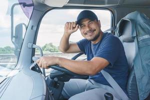 sorriso confiança jovem motorista de caminhão profissional em negócios de transporte longo foto