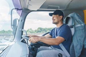 sorriso confiança jovem motorista de caminhão profissional em negócios de transporte longo foto