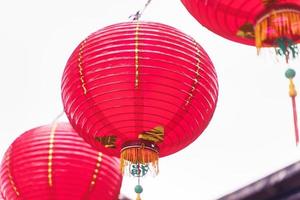 linda lanterna vermelha redonda pendurada na velha rua tradicional, conceito do festival chinês do ano novo lunar, close-up. a palavra subjacente significa bênção. foto