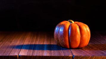 conceito de halloween - lanterna de abóbora laranja em uma mesa de madeira escura com fundo preto, gostosuras ou travessuras, close-up. foto