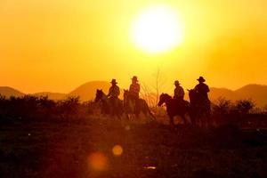 silhueta cowboy a cavalo contra um belo pôr do sol, cowboy e cavalo na primeira luz, montanha, rio e estilo de vida com fundo de luz natural foto