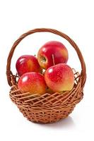 maçãs em uma cesta no fundo branco foto
