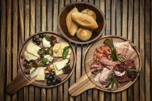 antipasto charcutaria gourmet e frios de queijo em tábua de madeira foto