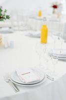 mesas de jantar redondas cobertas com pano azul em um pavilhão de casamento branco foto